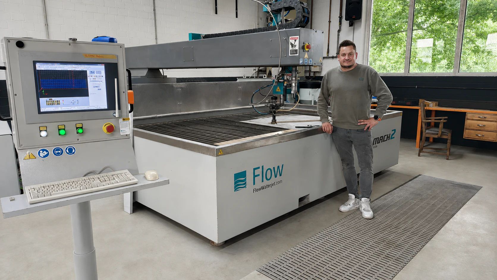 Addetto presso l’impianto di taglio a getto d’acqua Flow MACH 2 con comando, testa di taglio e piano