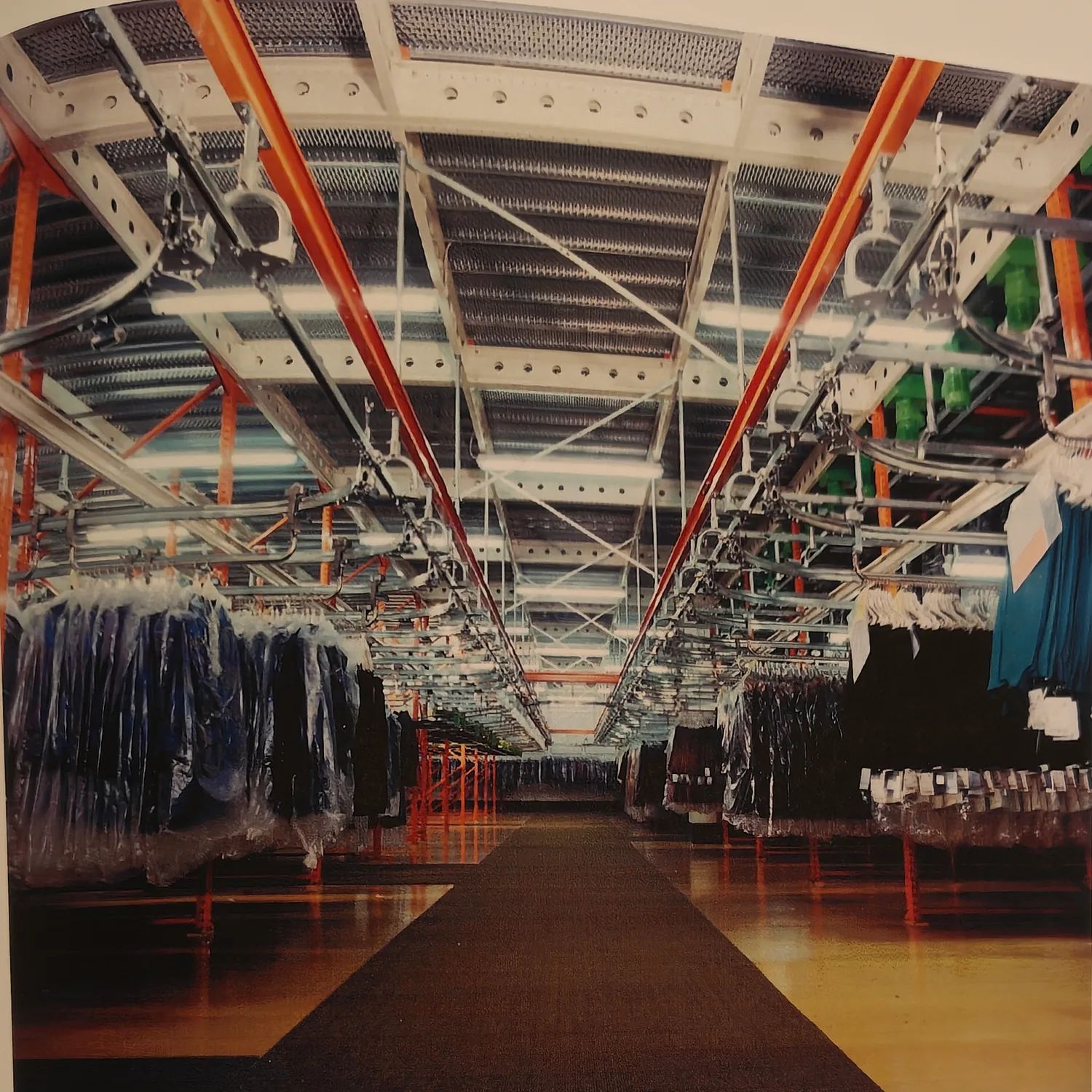 Historische Trollyanlage mit Schienenreihen und hängender Bekleidung in einer Produktionshalle.